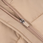 Close-up of beige quilted dog vest showing durable zipper closure and stitched padding detail.