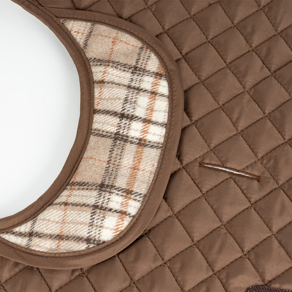 Close up of brown quilted dog jacket with plaid fleece collar lining