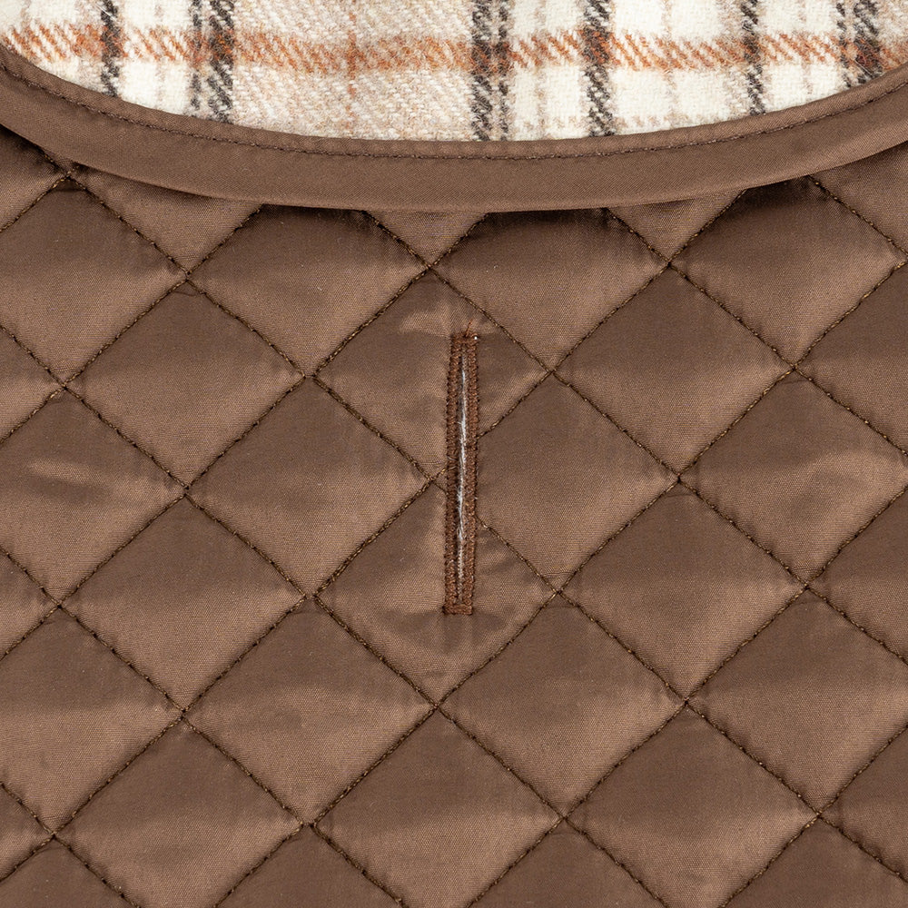 Detail of brown quilted winter dog jacket with reinforced stitching and leash hole