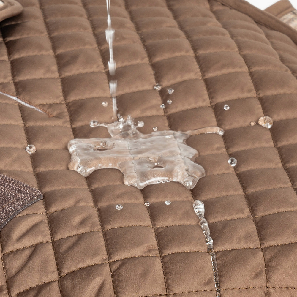 Water resistant brown quilted dog jacket with water beading on surface